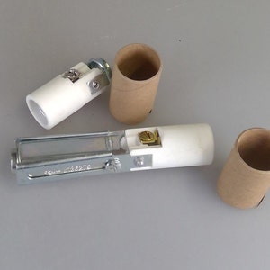 May include: Three white ceramic light bulb sockets with metal parts and two brown cardboard tubes.