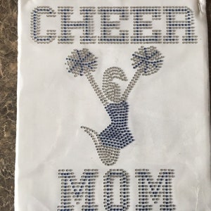 May include: White iron-on design featuring a cheerleading figure with pom-poms and the word "CHEER" above and "MOM" below.