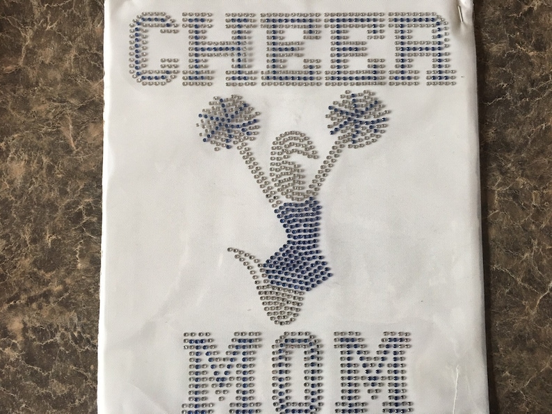 May include: White iron-on design featuring a cheerleading figure with pom-poms and the word "CHEER" above and "MOM" below.