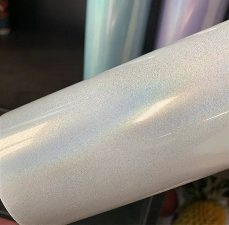 Puede incluir: Un vaso blanco iridiscente con un acabado liso y brillante. El vaso tiene un brillo sutil y un ligero efecto arco&iacute;ris.