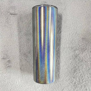 May include: A silver tumbler with a holographic finish. The tumbler has a smooth, shiny surface with a rainbow effect.