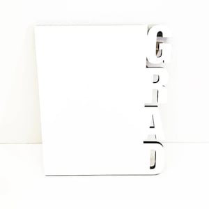 May include: White card with the word "GRAD" spelled out in large, white letters.