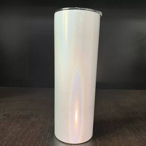 Puede incluir: Un vaso de acero inoxidable blanco con un acabado brillante e iridiscente. El vaso es alto y cil&iacute;ndrico, con una tapa.