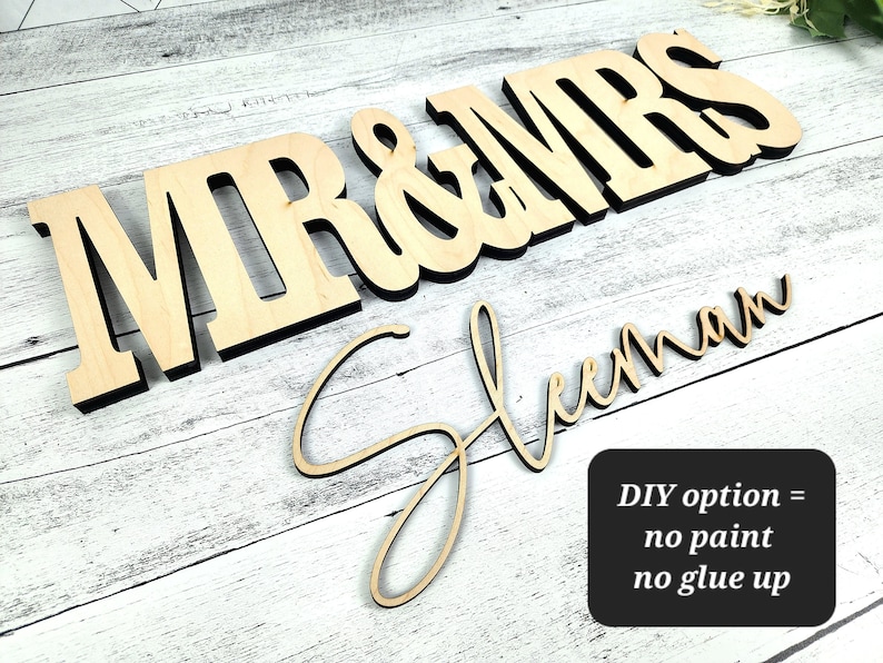 May include: Wooden "Mr & Mrs" sign with the last name "Sleeman" written in cursive underneath. DIY option = no paint, no glue up.