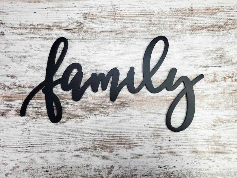 May include: Black metal wall decor with the word "family" written in a cursive script.