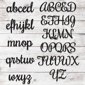 May include: A set of black cursive alphabet letters on a white wood background. The letters are arranged in alphabetical order, starting with "a" and ending with "z".
