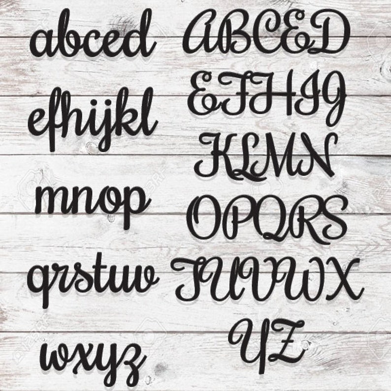 May include: A set of black cursive alphabet letters on a white wood background. The letters are arranged in alphabetical order, starting with "a" and ending with "z".