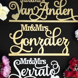Op de afbeelding: Drie gouden en zilveren glitter bruiloft borden met de tekst "Mr & Mrs Van Anden", "Mr & Mrs Gonzalez" en "Mr & Mrs Serrat".