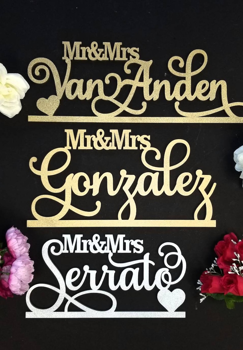 Op de afbeelding: Drie gouden en zilveren glitter bruiloft borden met de tekst "Mr & Mrs Van Anden", "Mr & Mrs Gonzalez" en "Mr & Mrs Serrat".