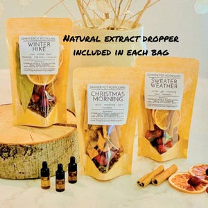 May include: Three stand-up pouches of simmer pot potpourri labeled Winter Hike, Christmas Morning, and Sweater Weather. Each bag contains dried fruit and spices. Three small glass dropper bottles and dried orange slices are included.