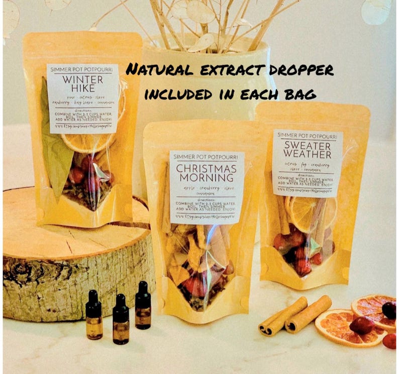 May include: Three stand-up pouches of simmer pot potpourri labeled Winter Hike, Christmas Morning, and Sweater Weather. Each bag contains dried fruit and spices. Three small glass dropper bottles and dried orange slices are included.