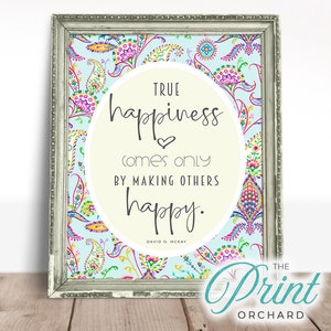 Puede incluir: Una impresión enmarcada con un fondo de patrón paisley colorido. La impresión presenta un círculo blanco con una cita en texto negro: "TRUE happiness comes only BY MAKING OTHERS happy." La cita se atribuye a David O. McKay. La impresión está enmarcada en un marco plateado.