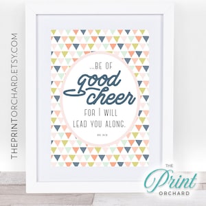 May include: A printable wall art design with a pink, blue, and green geometric pattern. The design features a circle with the text "...BE OF good cheer FOR I WILL LEAD YOU ALONG.  ZEC 18:18" in a blue circle.