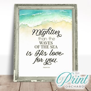 May include: A framed print with a watercolor background of ocean waves and a sandy beach. The print features the text "Mightier than the waves of the sea is His love for you." with the scripture reference "Psalm 93:4".
