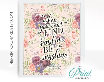 May include: A framed print with a floral background in shades of pink, peach, and green. The print features the quote "When you can't find the sunshine, be the sunshine" in elegant black script, attributed to "Unknown". The Print Orchard logo is in the bottom right corner.