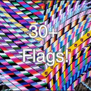 May include: A collection of over 30 colourful friendship bracelets, each woven with different coloured threads to represent various flags. The bracelets are arranged in a layered pattern, showcasing the intricate designs and vibrant colours.