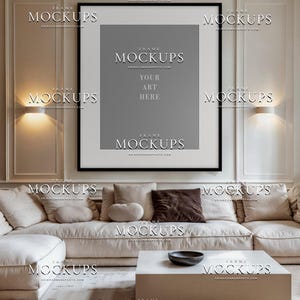 Blank square frame mockup in contemporary taupe living room with cream sofa, wall trim, warm sconces, table lamp, neutral curtains, and soft decor