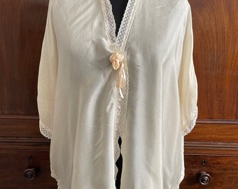 A vintage bed jacket in cream fine soft silk, edged with lace. 1920s/30s.