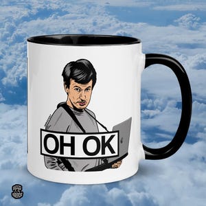 May include: White ceramic mug with a black interior and handle. The mug features a cartoon illustration of a person holding a laptop with the text "OH OK" in a black rectangle. The background is a cloudy sky.