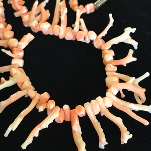 Op de afbeelding: Een roze koraal ketting met een delicaat, takvormig ontwerp. De ketting is gemaakt van natuurlijk koraal en heeft een unieke, organische uitstraling.