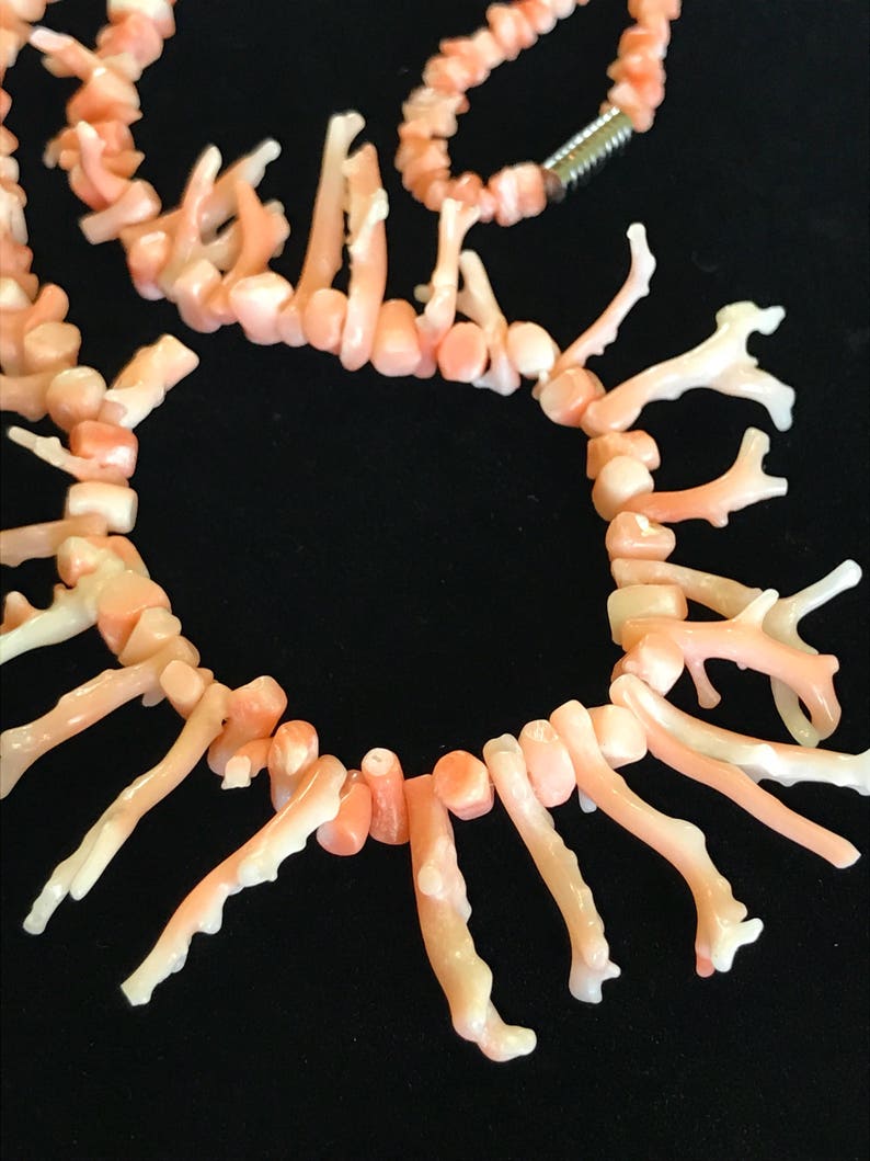 Op de afbeelding: Een roze koraal ketting met een delicaat, takvormig ontwerp. De ketting is gemaakt van natuurlijk koraal en heeft een unieke, organische uitstraling.