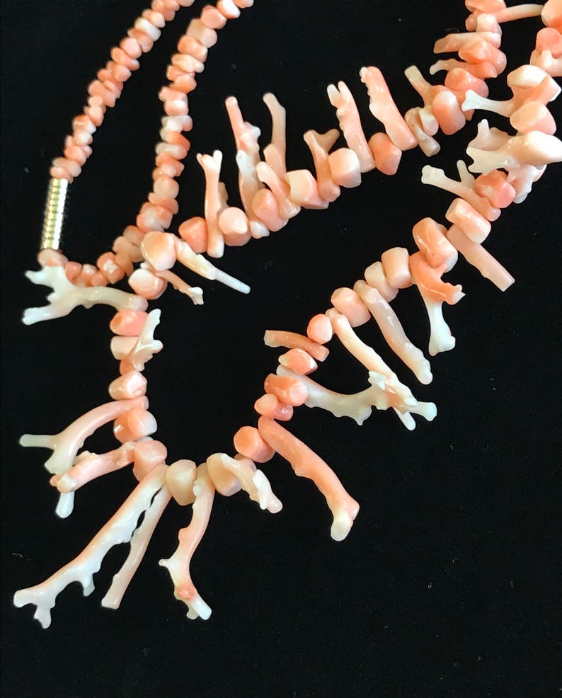 Op de afbeelding: Een roze koraal ketting met een zilveren sluiting. Het koraal is in de vorm van kleine takken.