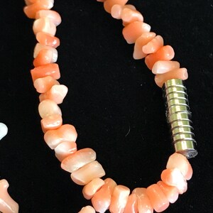 Op de afbeelding: Een roze koraal ketting met een zilveren magneetsluiting. De ketting is gemaakt van onregelmatig gevormde koraal kralen.