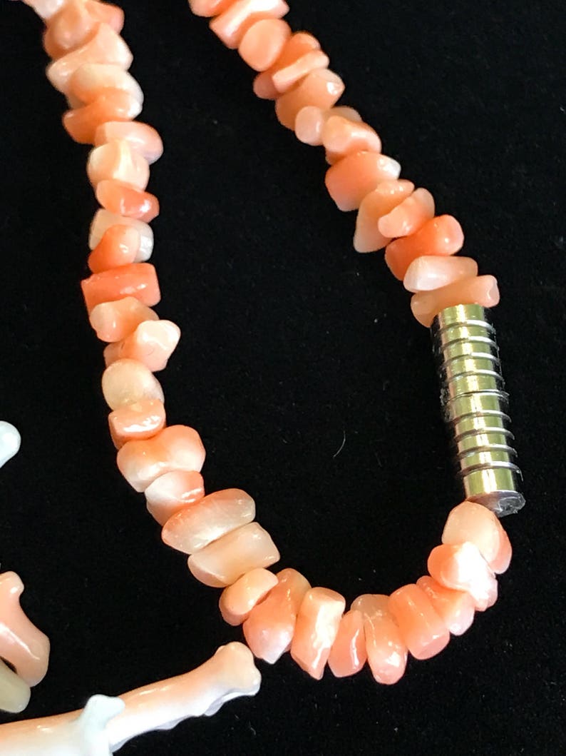 Op de afbeelding: Een roze koraal ketting met een zilveren magneetsluiting. De ketting is gemaakt van onregelmatig gevormde koraal kralen.