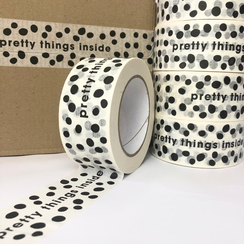 May include: A roll of white packing tape with black polka dots and the text "pretty things inside" printed on it.