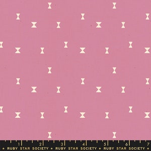 May include: Pink fabric with a repeating pattern of off-white bow tie shapes. The fabric has a slightly textured appearance. The bottom of the image includes the text "RUBY STAR SOCIETY" and a ruler.