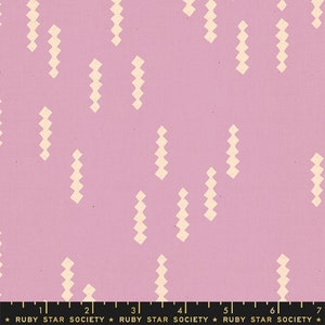 May include: A pink fabric with a repeating pattern of cream-colored, zig-zag shapes. The fabric has a textured appearance and a ruler is at the bottom of the image. The text "RUBY STAR SOCIETY" is printed on the ruler.