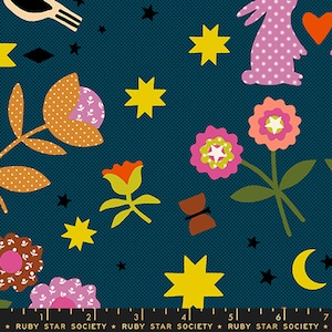 Può includere: Un tessuto blu ottanio scuro con un motivo ripetuto di conigli rosa, cuori arancioni, stelle gialle, una luna crescente gialla e vari fiori stilizzati nei toni del rosa, arancione e marrone. Un righello in basso indica 18 cm.
