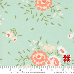 May include: Floral fabric with a light green background. The fabric features large peach-colored flowers with white and green accents, along with smaller white flowers and green leaves. The fabric has a ruler along the bottom.