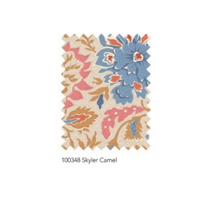 May include: A fabric swatch with a floral pattern in shades of beige, pink, blue, and orange. The design includes large stylized flowers and leaf motifs. The text "100348 Skyler Camel" is printed at the bottom of the swatch.