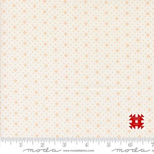 May include: Cream-colored fabric with a repeating pattern of small, orange diamond-shaped dots. The fabric has a ruler along the bottom edge, with measurements in inches. A red and white logo is in the bottom right corner.