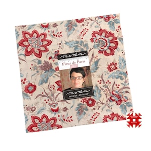 Op de afbeelding: Vierkantige stofstaal met een bloemenpatroon in rood, blauw en beige. Het ontwerp toont grote gestileerde bloemen en bladeren. Een label leest "Fleur de Paris" en bevat een foto van een vrouw.