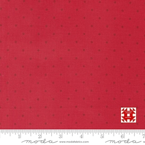 May include: Red fabric with small, evenly spaced brown dots. The fabric has a textured appearance and a ruler is visible along the bottom edge. A logo is in the bottom right corner.