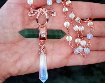 Pode incluir: Um colar de ouro rosa com um pingente de pedra verde e uma ponta de opala branca. O colar é feito de fio envolto com contas de opala.