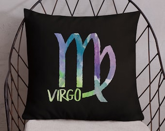 May include: A black throw pillow with a watercolor-style Virgo zodiac sign in shades of purple, blue, and green. The word "Virgo" is written in green below the sign.
