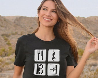 May include: Black t-shirt with a white graphic design of four icons: a fork and knife, a treble clef, a bass clef, and a musical staff. The text "PICADILLY PRINTABLES" is visible in the bottom right corner.