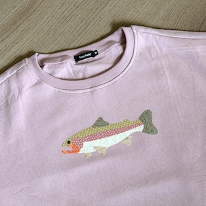 May include: A light purple sweatshirt with a crew neck and a fish applique. The fish has a white belly, pink and green patterned body, and orange and yellow accents. The brand name "EasyGala" is on the tag.