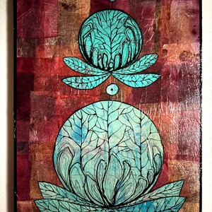 Puede incluir: Obra de arte abstracta con dos formas turquesas, similares a flores, con intrincados detalles de líneas negras, sobre un fondo texturizado de cuadrados rojos y marrones. La obra está enmarcada con un borde negro.