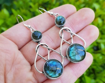 May include: Silver dangle earrings with a knotted design and two round labradorite stones.