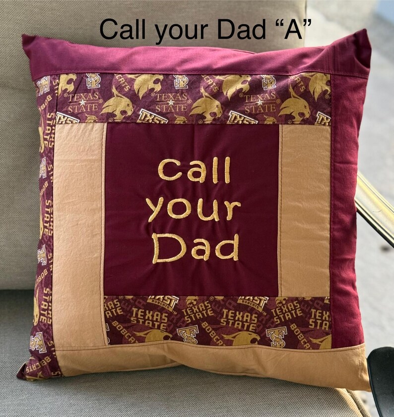 May include: A maroon and tan pillow with the words "Call your Dad" embroidered in gold thread. The pillow is decorated with a repeating pattern of Texas State Bobcats logos.