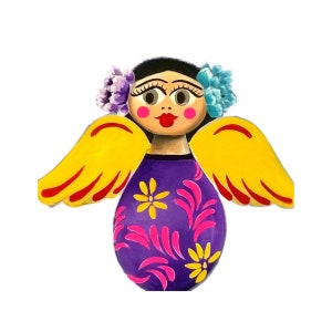 May include: A wooden angel figurine with yellow wings, a purple dress with pink and yellow floral designs, and a painted face with blue flowers in her hair.