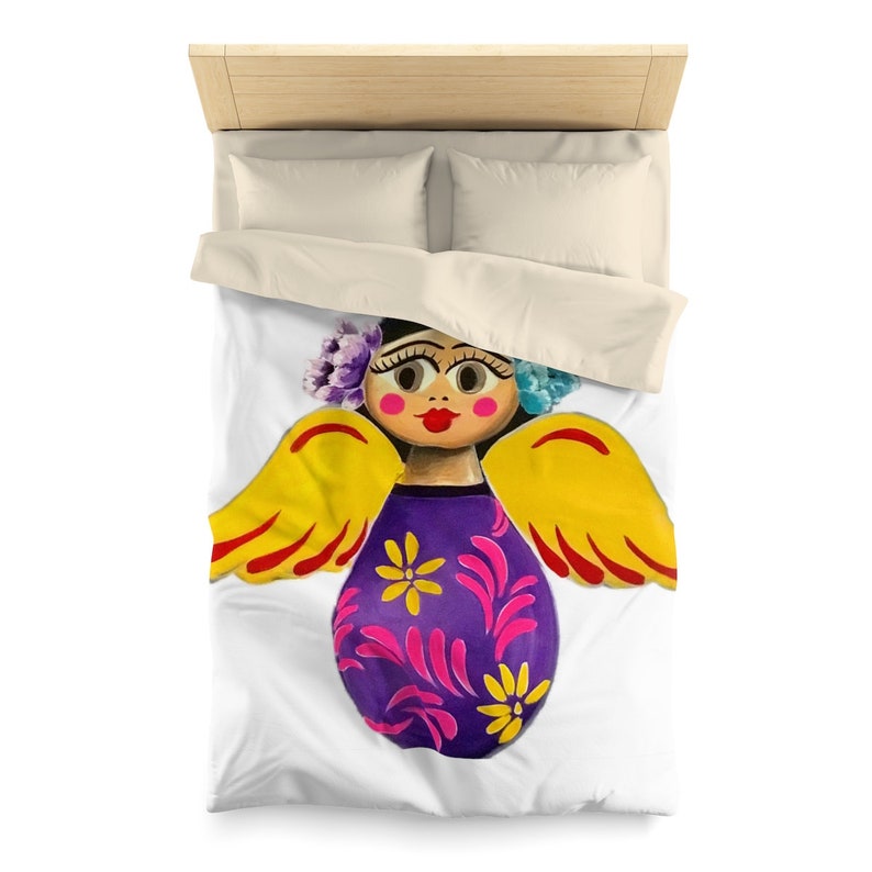 May include: A colorful angel figurine with yellow wings, a purple dress with pink and yellow flowers, and a flower crown. The angel has a painted face with brown eyes, red lips, and rosy cheeks.