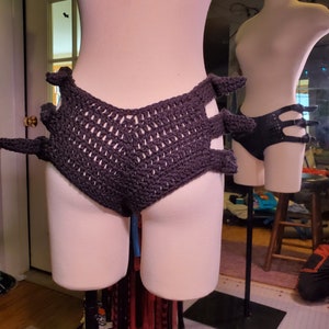 May include: Black crocheted underwear with a unique design featuring cutouts and a high-waisted fit.