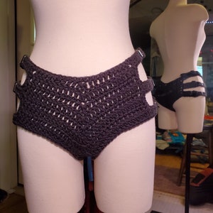 May include: Black crocheted bikini bottom with adjustable straps. The bikini bottom is made with a simple crochet stitch and has a high-cut leg.