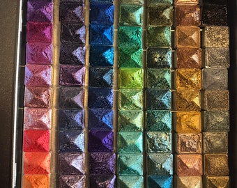 May include: A metal palette with 80 small squares filled with different shades of metallic paint. The palette is organized in rows of 8 squares, with each row featuring a different color gradient.