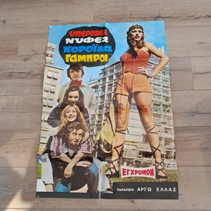 May include: A vintage film poster with a colourful design featuring a woman in a short skirt and a group of people. The poster is titled "ΥΠΕΡΟΧΕΣ ΝΥΦΕΣ ΚΟΡΟΪΔΑ ΓΑΜΠΡΟΙ" and has the text "ΕΓΧΡΩΜΟΝ ΠΑΡΑΓΩΓΗ ΑΡΓΟΣ ΕΛΛΑΣ" at the bottom.